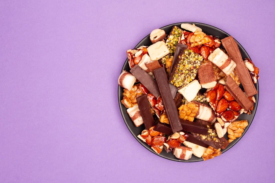 A black plate filled with assorted chocolate bars and snacks.