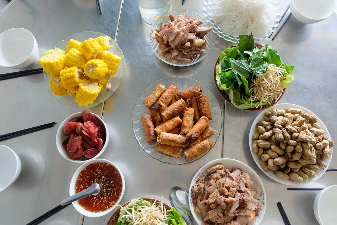A table filled with various vietnamese dishes and ingredients.