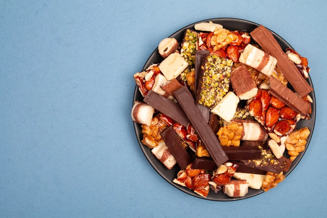 A dark plate filled with assorted chocolates and nuts.