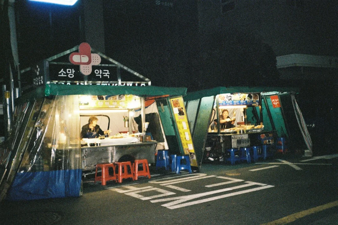 Street vendors operate at night under small tents.