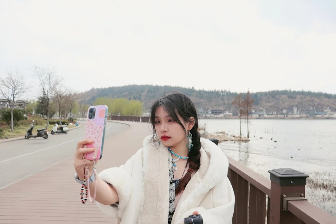 Woman takes a selfie by the water.