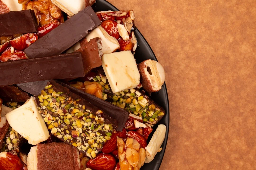 A close-up of assorted chocolates and nuts on a plate.