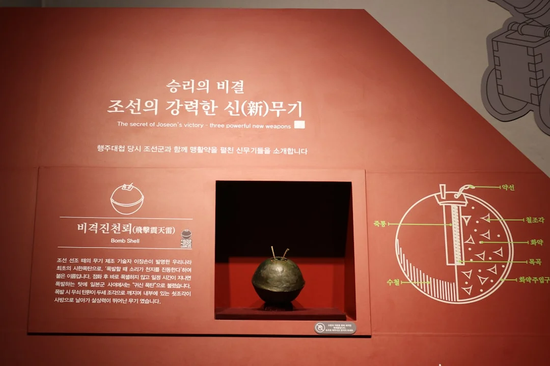 Ancient korean bomb artifact displayed in a red museum exhibit.