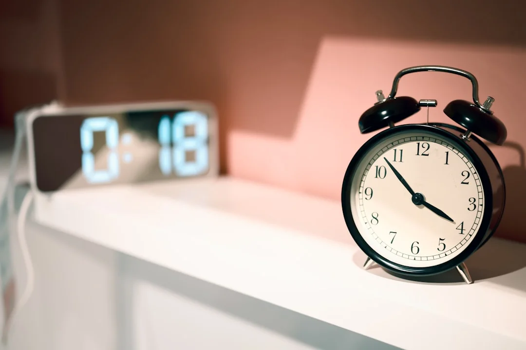 Two alarm clocks on a shelf