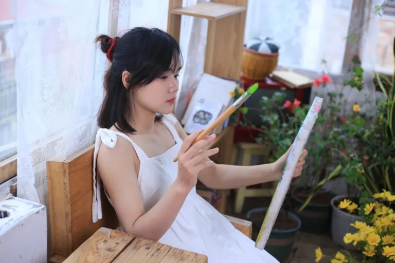 a woman sitting on a bench holding a brush
