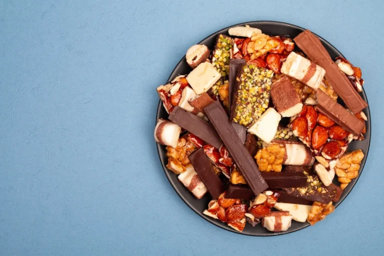 A dark plate filled with assorted chocolates and nuts.