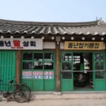 Old storefront with bicycle and korean signage.