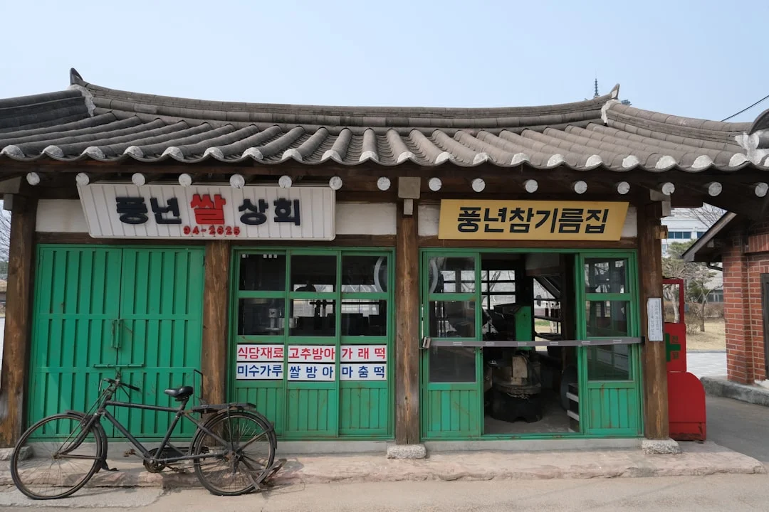 Old storefront with bicycle and korean signage.