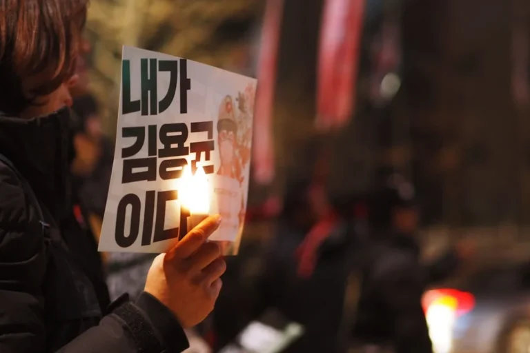 person holds banner with candle