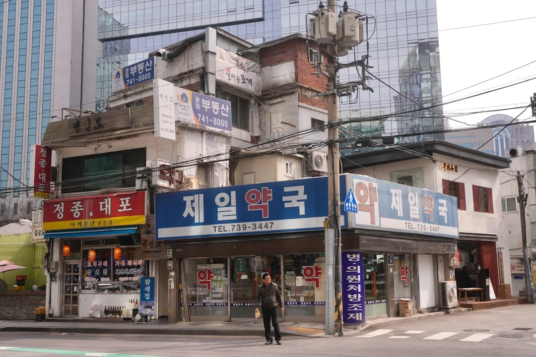 Old shops stand before modern buildings in a city.
