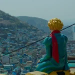a statue of a man sitting on top of a building