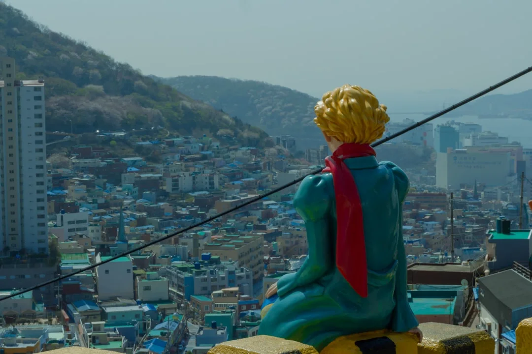 a statue of a man sitting on top of a building