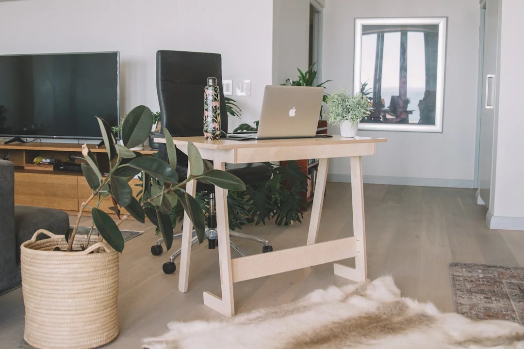 silver macbook on white wooden table