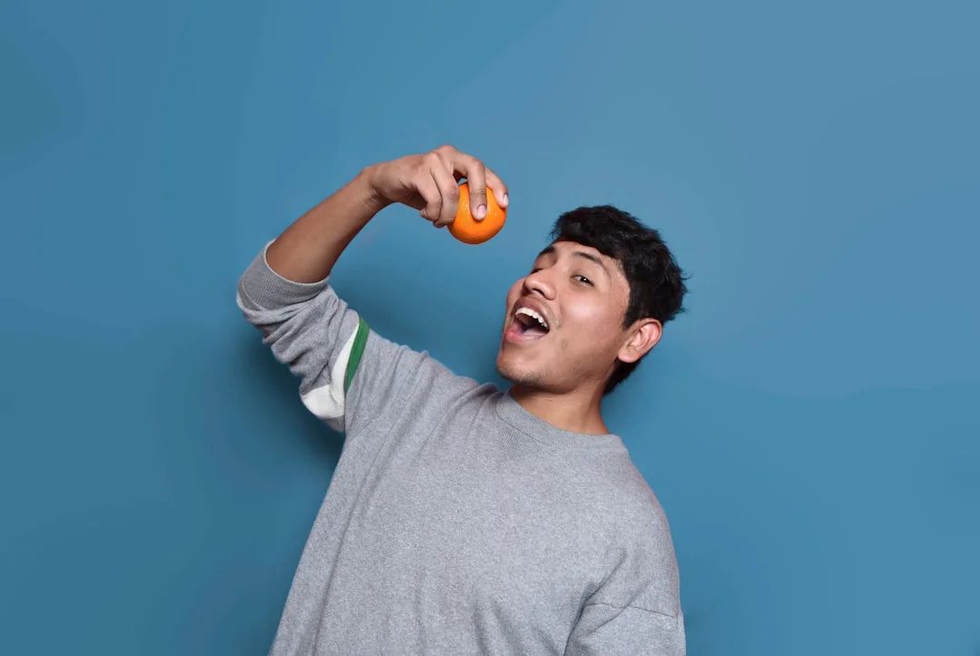 man about to eat orange fruit