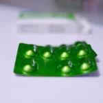 a group of green pills sitting on top of a table