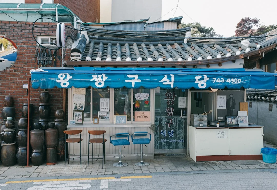 a small asian restaurant with a blue awning