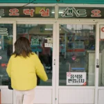 A woman standing in front of a store front