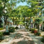 A tree-lined street with shops and businesses.