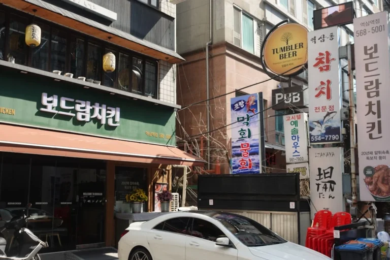 Street view of korean restaurants and shops with signs.