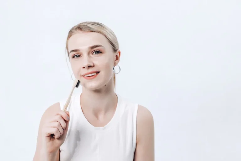a woman holding a toothbrush in her right hand