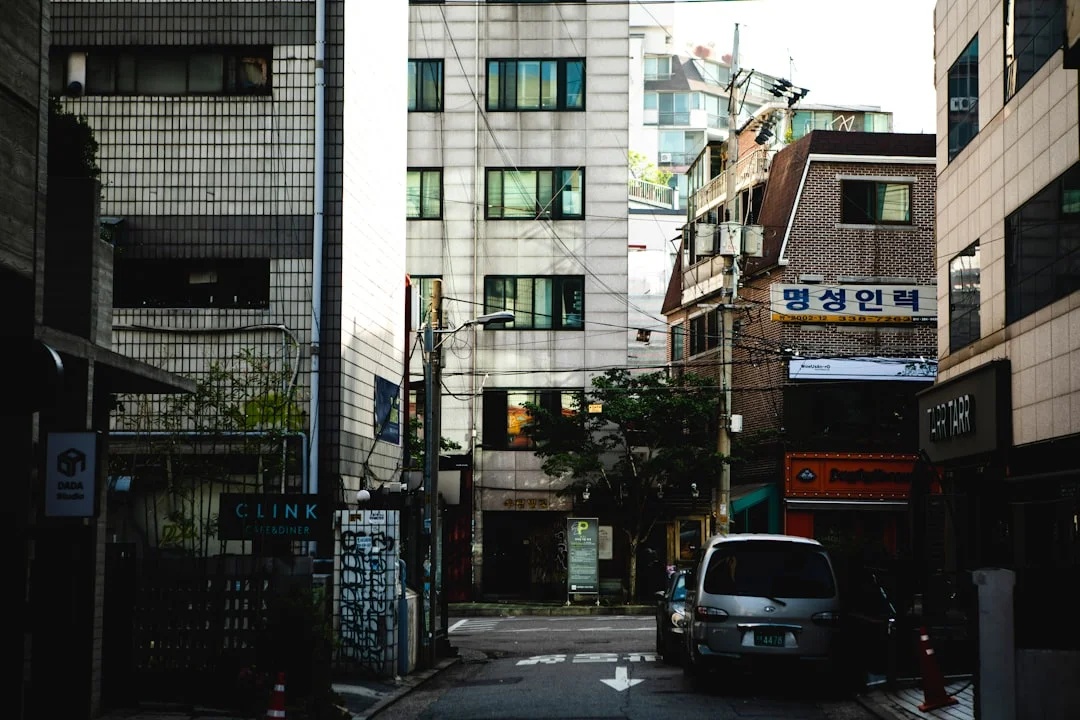 a car driving down a street next to tall buildings