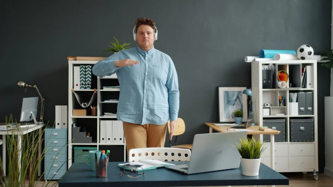 Man wearing headphones gestures in a modern office.