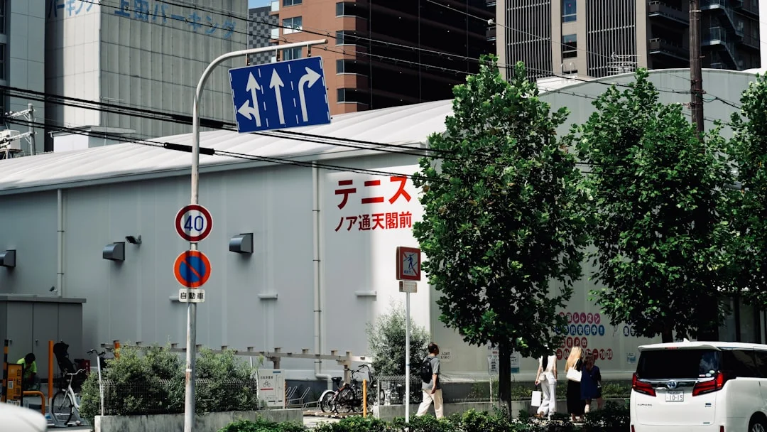 A group of people walking down a street next to tall buildings