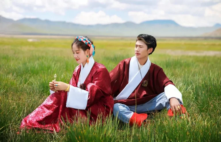 man in red suit sitting on green grass field
