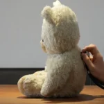 Hand using stethoscope on a teddy bear's back