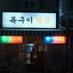 a building with a neon sign in front of it