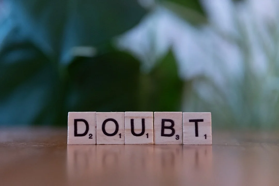 A wooden block spelling doubt on a table