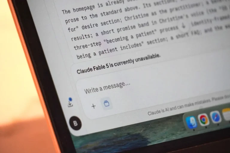 A laptop screen displays "claude fable 5 is currently unavailable."