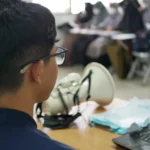 a man sitting at a desk using a laptop computer