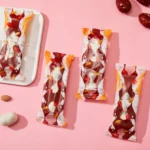a pink table topped with candy bars and almonds