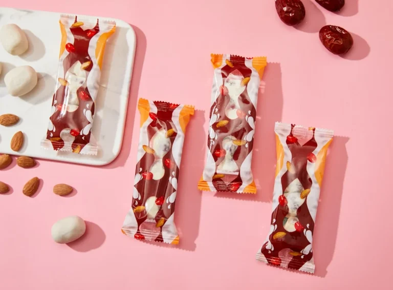 a pink table topped with candy bars and almonds
