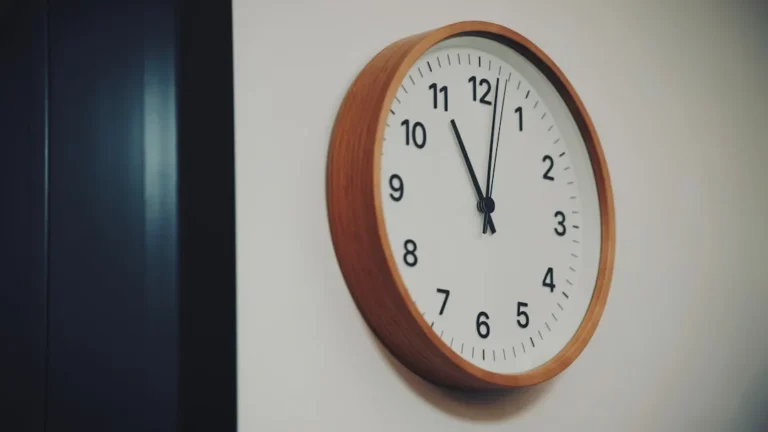 a wooden clock mounted to the side of a wall