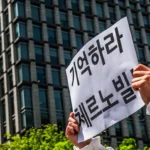 A woman holding a sign in front of a building