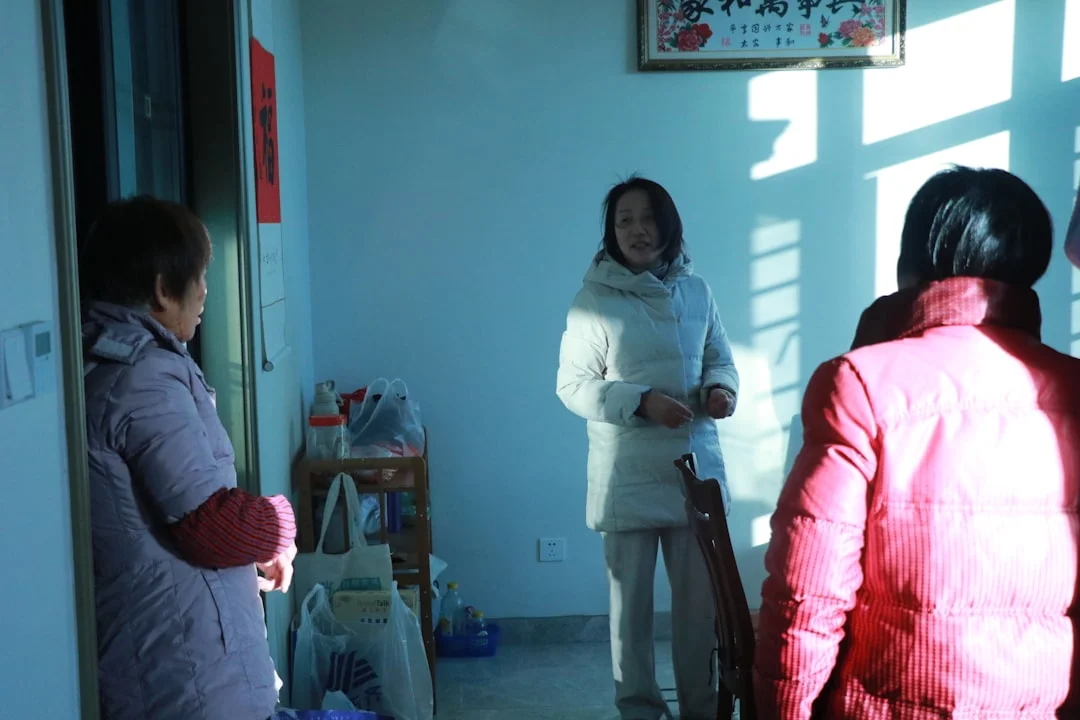 People stand inside a room on a sunny day.