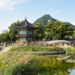 a small building sitting on top of a lush green hillside
