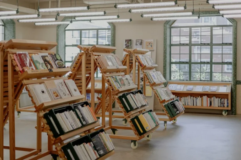 a room filled with lots of books next to windows